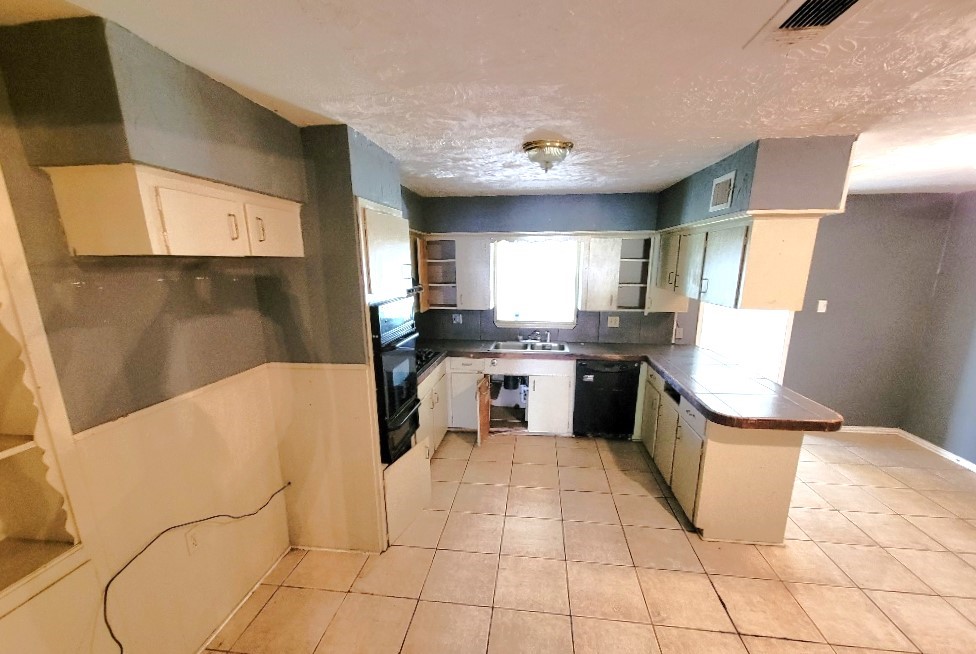 705 Inwood Drive Baytown, TX 77521 - Photo 8 of 15 a kitchen with stainless steel appliances kitchen island granite countertop a refrigerator a sink a stove a microwave and cabinets