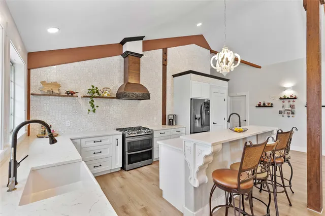 a bedroom with a large bed and a chandelier