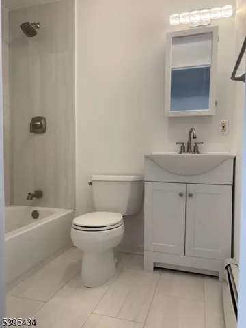 a bathroom with a toilet sink vanity tub and mirror