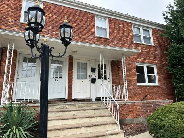 a front view of a house with a garden and plants