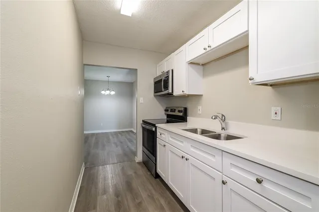 a kitchen with a sink cabinets and a stove top oven