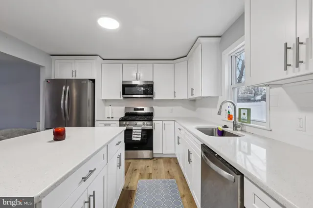 a kitchen with a sink a stove a refrigerator cabinets and a center island