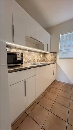 a kitchen with granite countertop a sink and a stove top oven