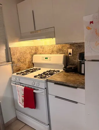 a stove top oven sitting inside of a kitchen