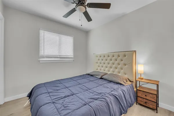 a bedroom with a bed and a painting on the wall