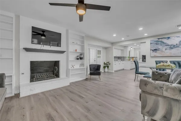 a living room with furniture a fireplace and a flat screen tv