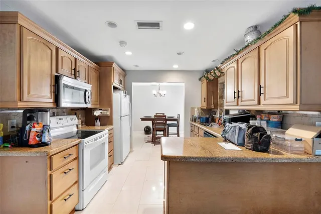 a kitchen with stainless steel appliances granite countertop a sink dishwasher stove and cabinets with wooden floor