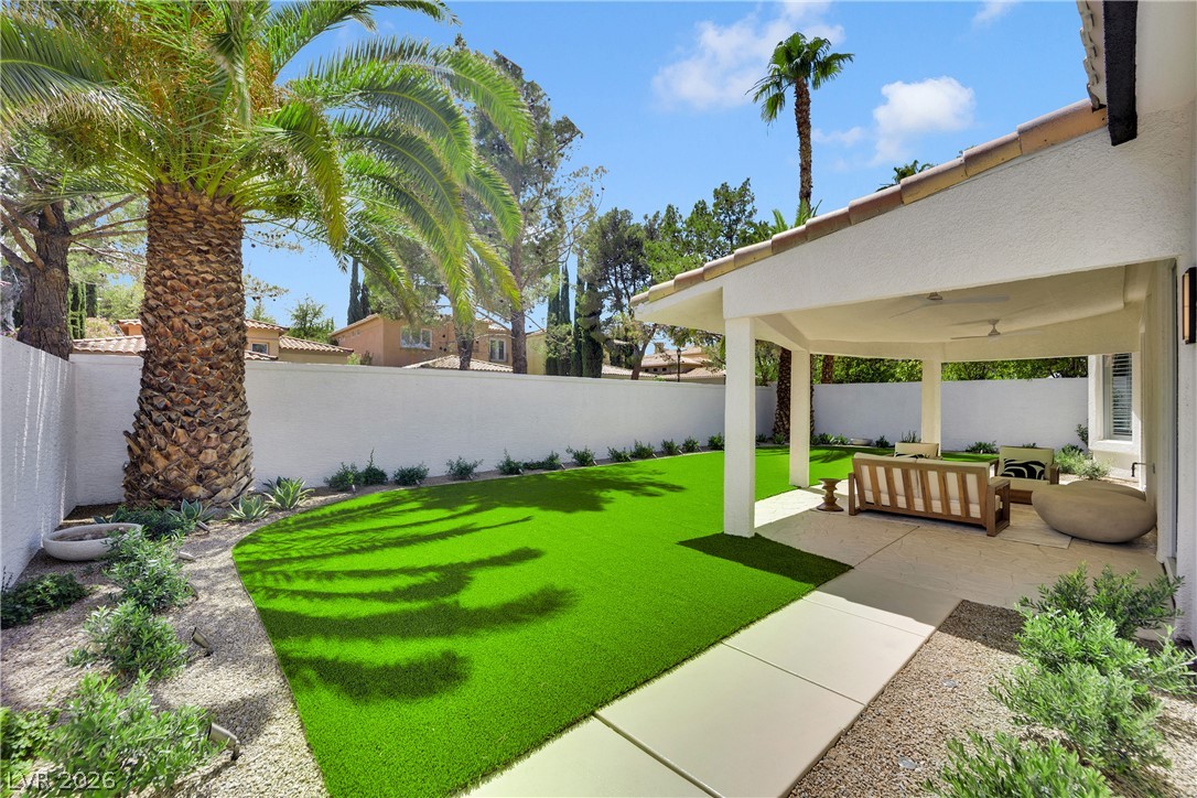 8981 Rivers Edge Drive Las Vegas, NV 89117 - Photo 48 of 69 A private backyard oasis with synthetic turf and a shaded patio awaits tranquil relaxation.