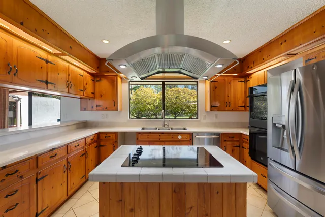 a kitchen with stainless steel appliances granite countertop a sink and a refrigerator