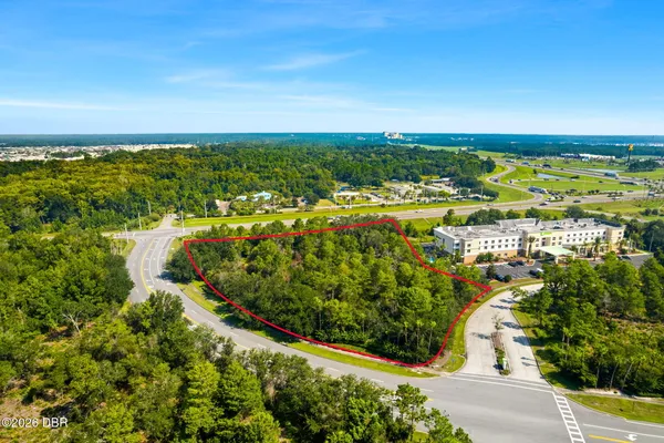 an aerial view of residential houses with outdoor space and trees all around