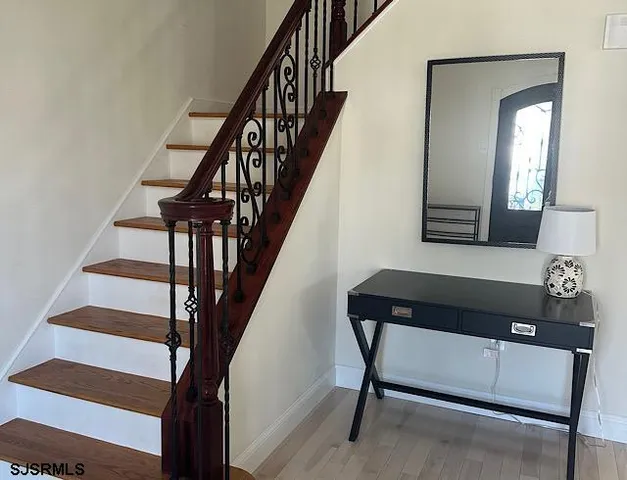 a view of entryway and hall with wooden floor