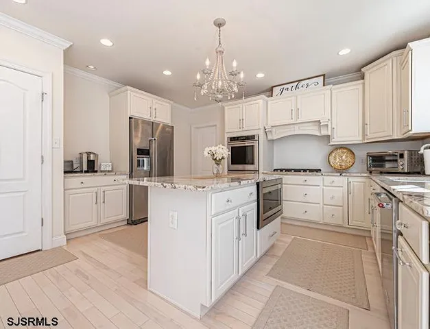 a kitchen with white cabinets stainless steel appliances and sink