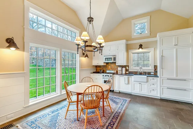 a dining room with wooden floor a chandelier a wooden table and chairs