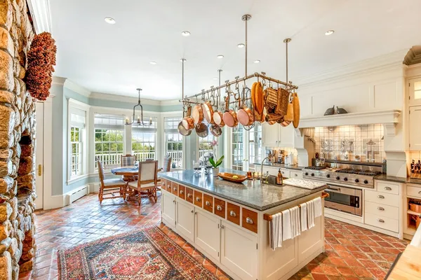 a kitchen with a stove oven and a view of living room