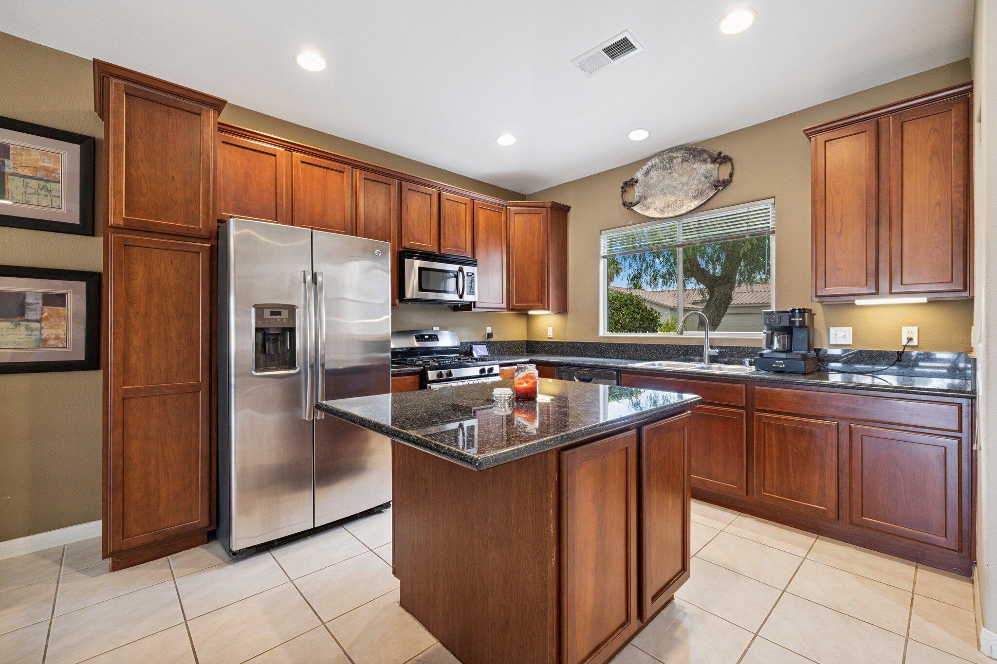 49151 Biery Street Indio, CA 92201 - Photo 2 of 26 a kitchen with stainless steel appliances granite countertop a sink stove refrigerator and cabinets