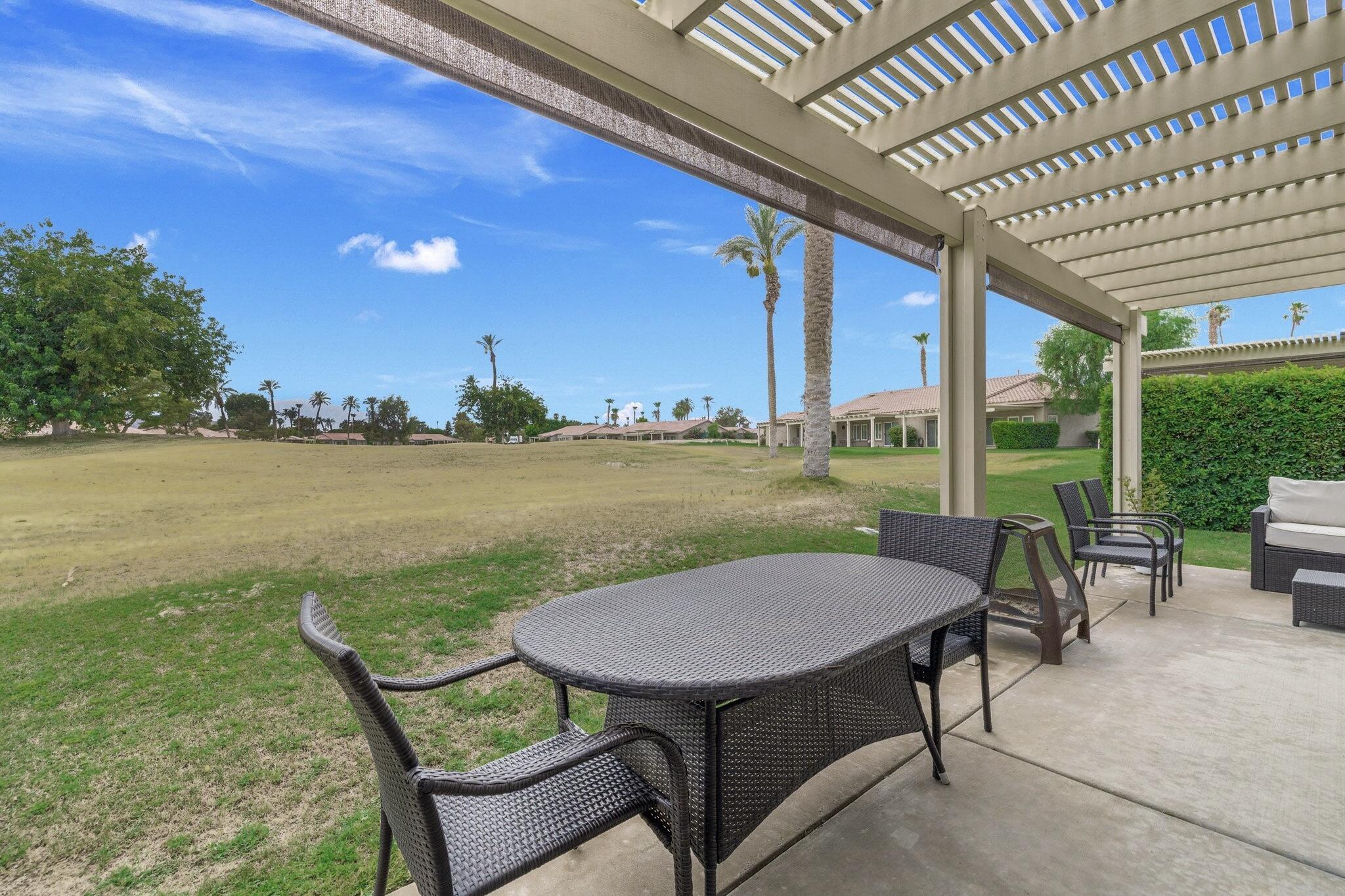 49151 Biery Street Indio, CA 92201 - Photo 21 of 26 a view of a patio with lawn chairs and couches chairs with large trees