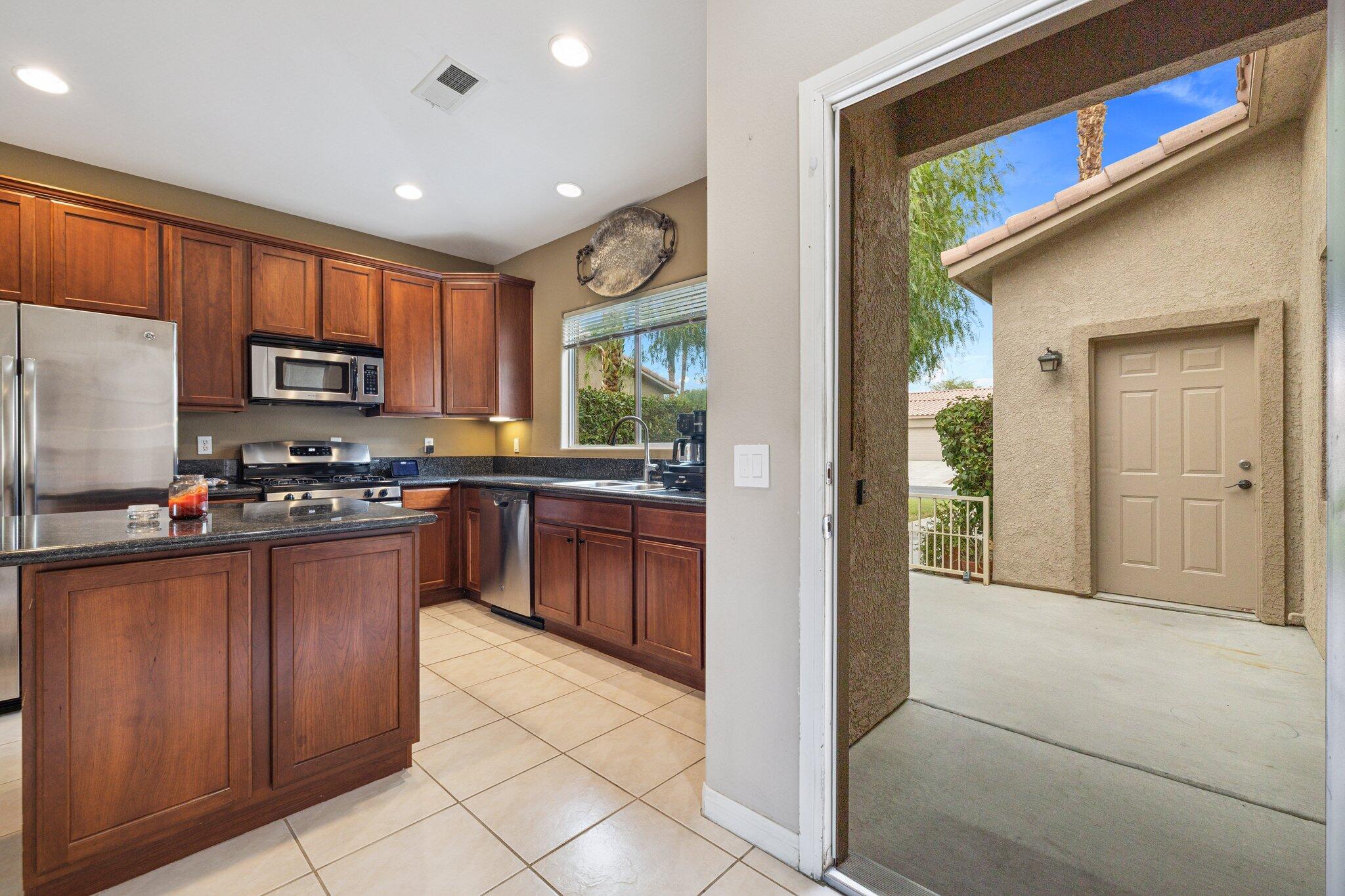49151 Biery Street Indio, CA 92201 - Photo 9 of 26 a kitchen with stainless steel appliances granite countertop a refrigerator and a stove top oven
