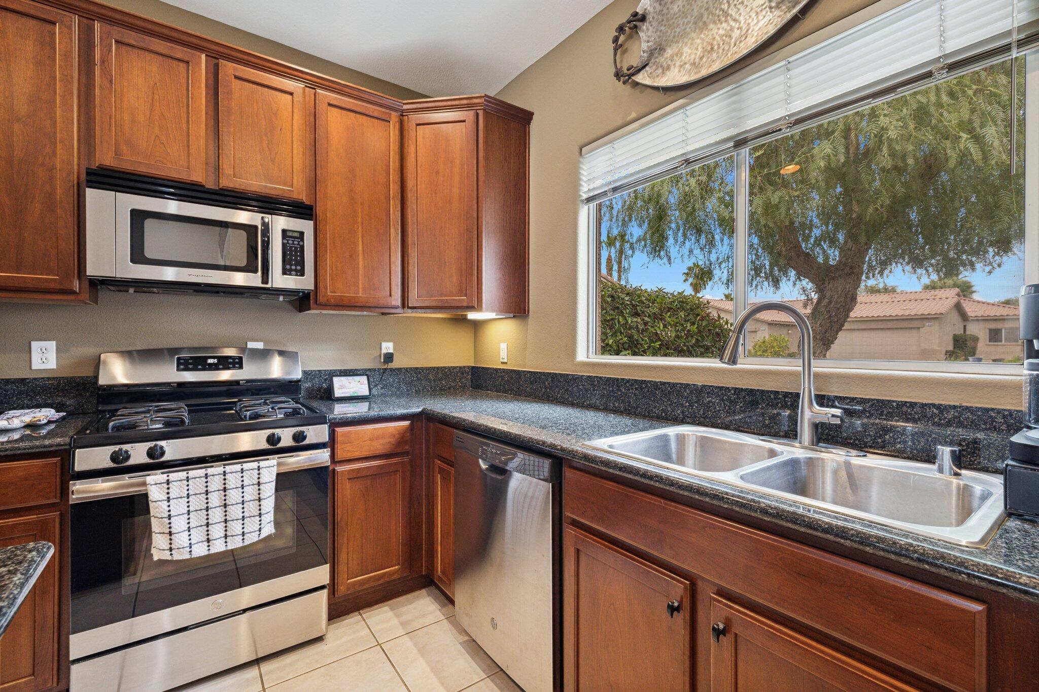 49151 Biery Street Indio, CA 92201 - Photo 10 of 26 a kitchen with stainless steel appliances granite countertop a sink stove and microwave