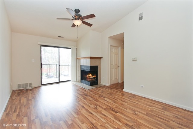 2028 North Rand Road, Unit 201 Palatine, IL 60074 - Photo 3 of 12 a view of an empty room with wooden floor fireplace and a window