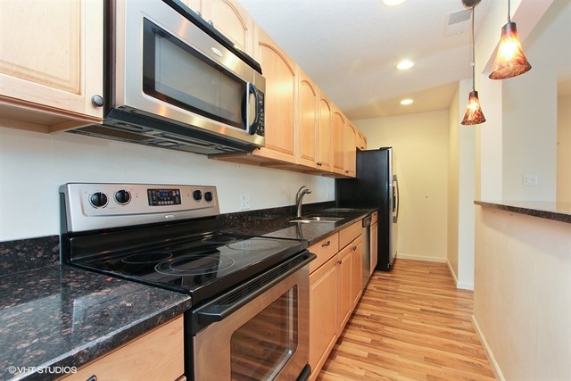 2028 North Rand Road, Unit 201 Palatine, IL 60074 - Photo 4 of 12 a kitchen with stainless steel appliances granite countertop a stove and a microwave