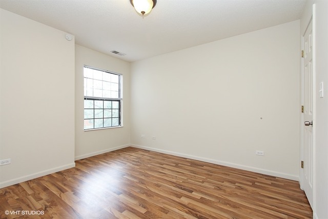 2028 North Rand Road, Unit 201 Palatine, IL 60074 - Photo 5 of 12 an empty room with wooden floor and windows