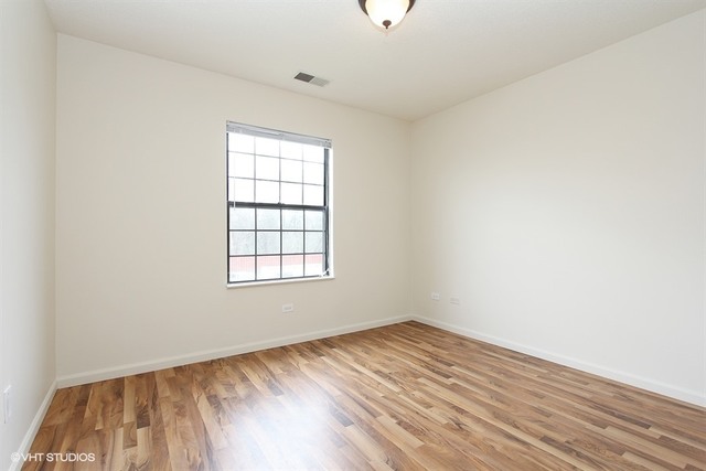 2028 North Rand Road, Unit 201 Palatine, IL 60074 - Photo 7 of 12 an empty room with wooden floor and windows