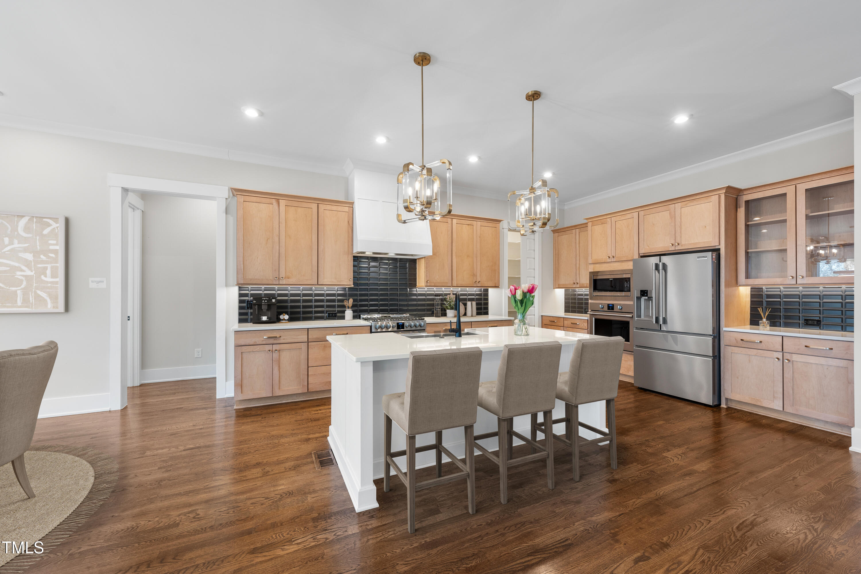 729 Daniel Rdg Road Wendell, NC 27591 - Photo 4 of 57 a large kitchen with kitchen island granite countertop a dining table chairs stainless steel appliances and wooden floor