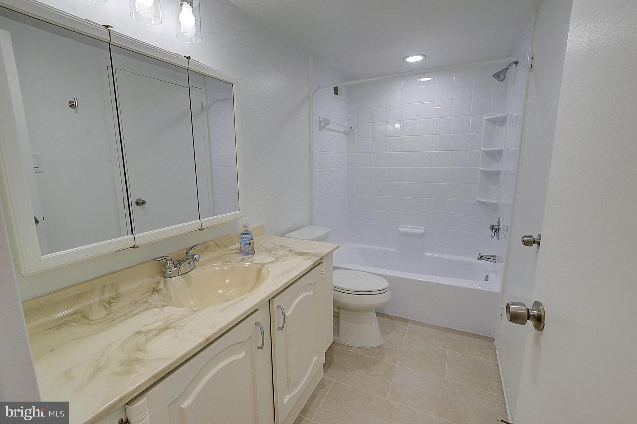 5225 Pooks Hill Road, Unit 1005S Bethesda, MD 20814 - Photo 5 of 32 a bathroom with a granite countertop sink a toilet and shower