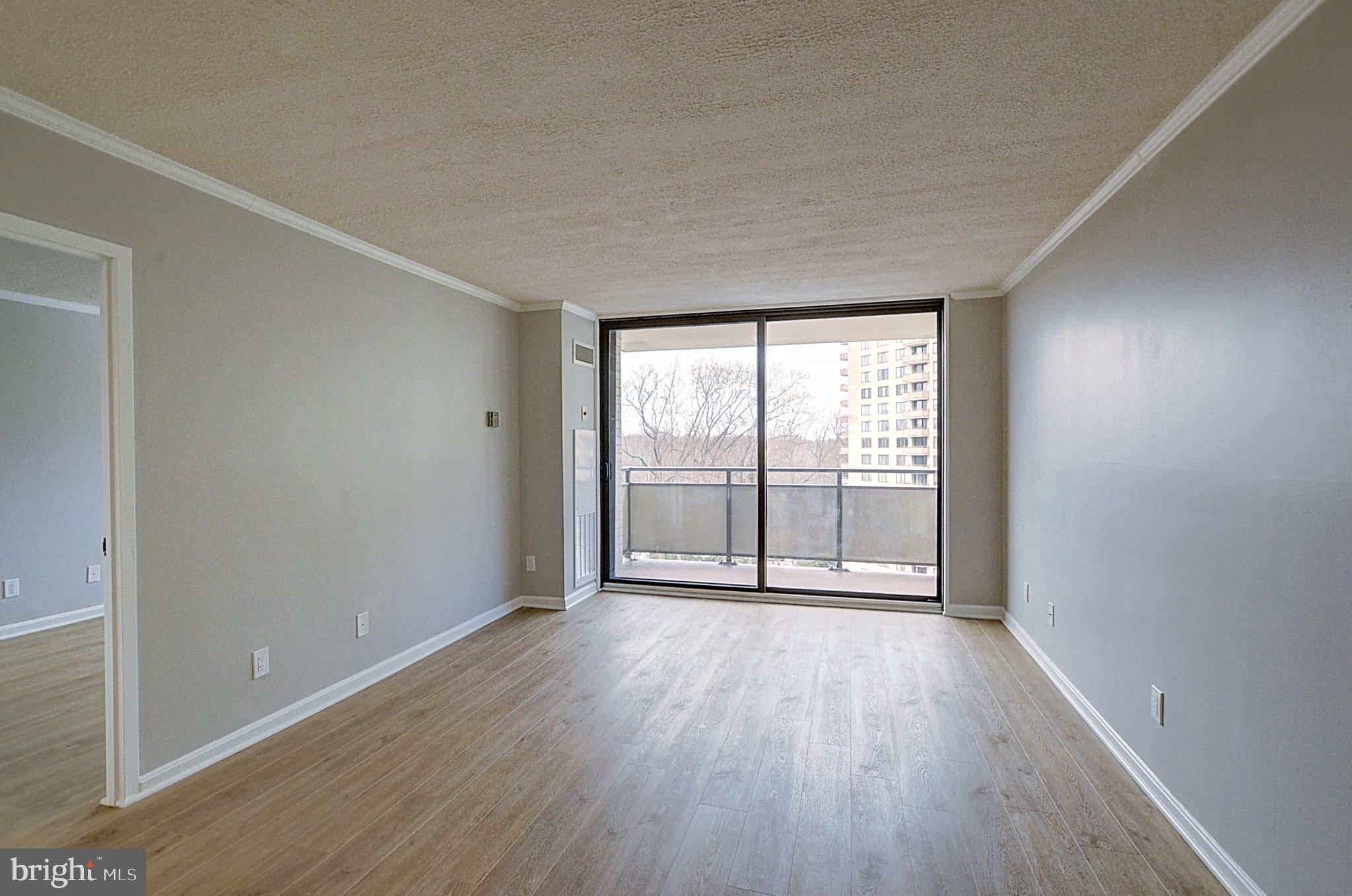 5225 Pooks Hill Road, Unit 1005S Bethesda, MD 20814 - Photo 9 of 32 a view of an empty room with wooden floor and a window