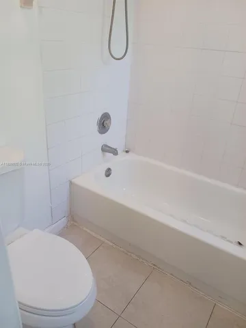 a bathroom with a toilet and a bath tub