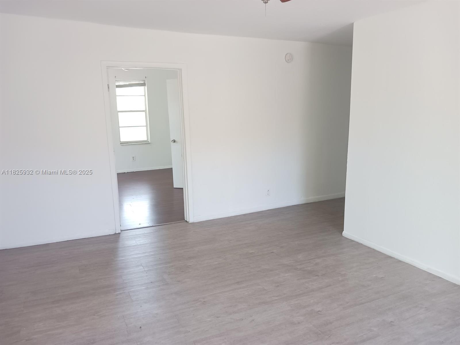 706 9th Street, Unit 2 West Palm Beach, FL 33401 - Photo 7 of 9 an empty room with wooden floor and windows