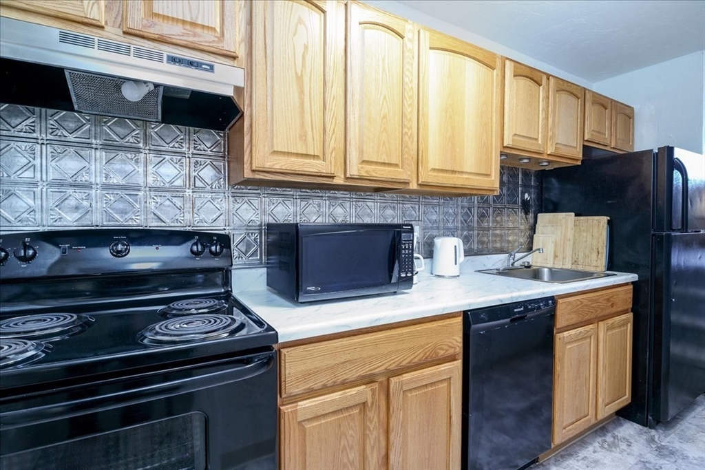 531 Main Street, Unit 503 Worcester, MA 01608 - Photo 12 of 21 a kitchen with stainless steel appliances granite countertop a stove a sink and a microwave