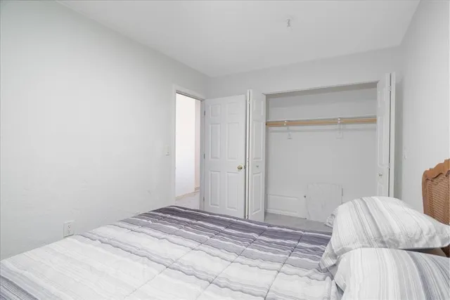 a bedroom with a bed and a white wall