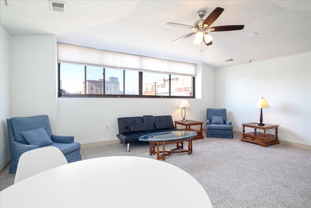 531 Main Street, Unit 503 Worcester, MA 01608 - Photo 4 of 21 a work room with furniture and a lamp