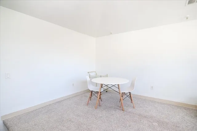 a view of a room with a table and chairs