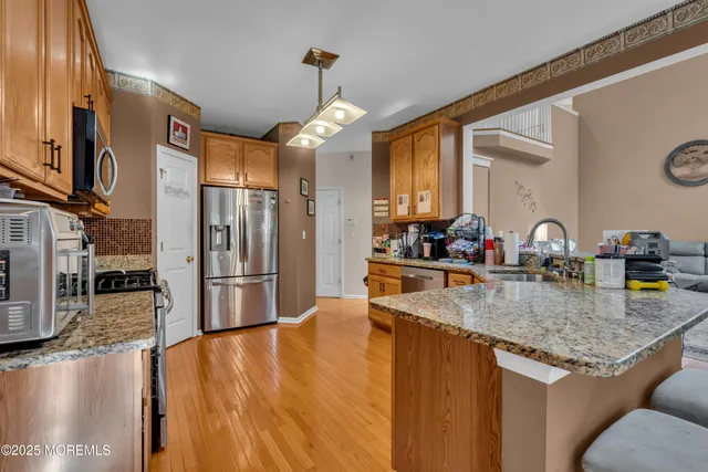 a kitchen with stainless steel appliances granite countertop a sink refrigerator and cabinets