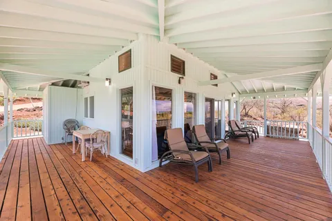 a kitchen with stainless steel appliances granite countertop a stove a refrigerator a dining table and chairs with wooden floor