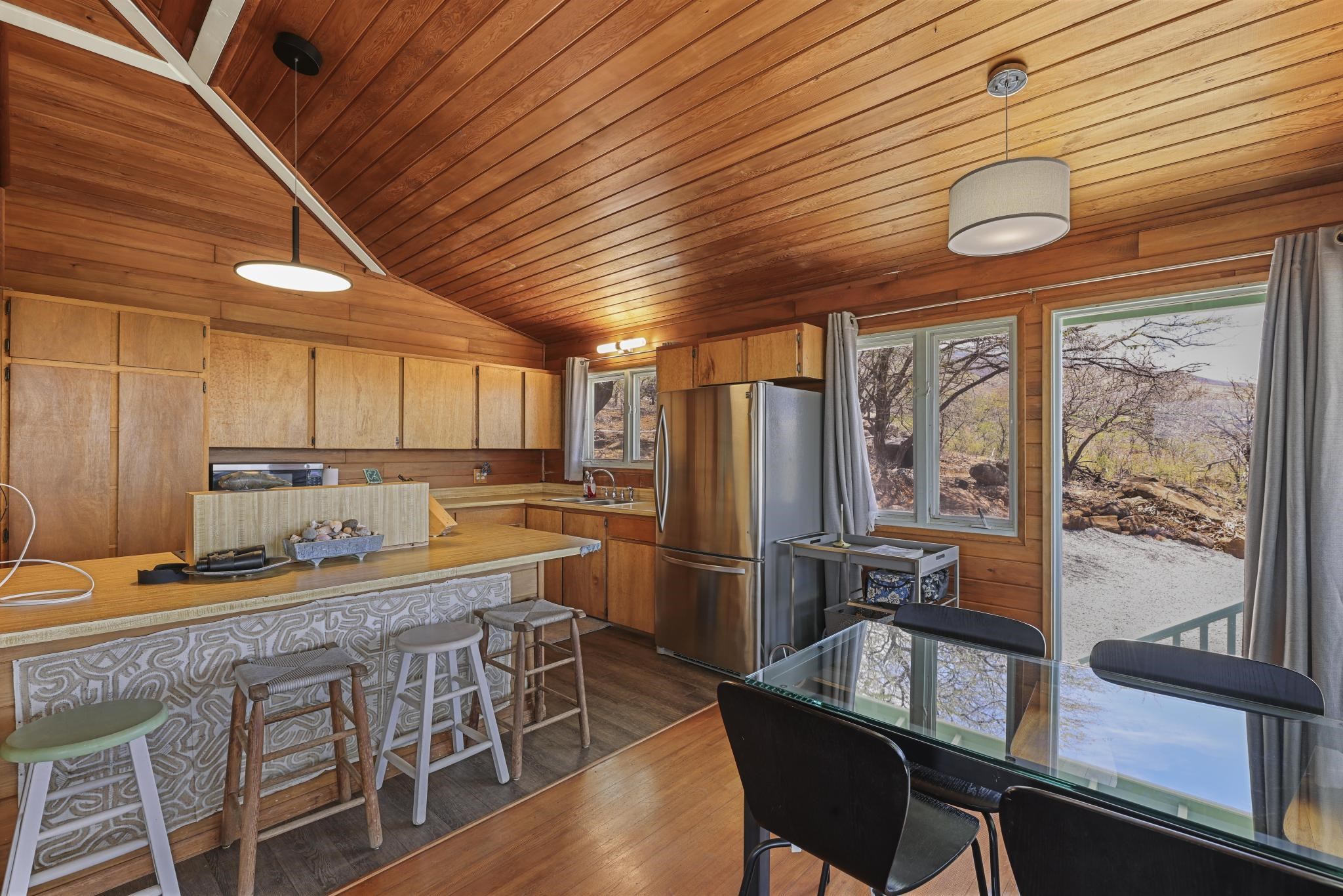 122 Ulua Road Kaunakakai, HI 96748 - Photo 38 of 48 a kitchen with stainless steel appliances granite countertop a table chairs and a refrigerator