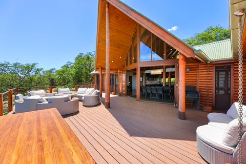 a view of a patio with couches and table and chairs with wooden floor and fence