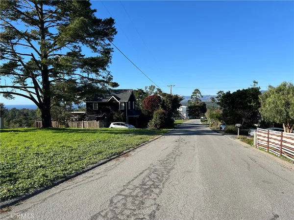a street view with flower garden and wooden fence