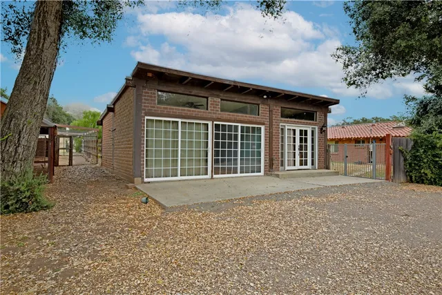 a view of a house with brick walls and a tree
