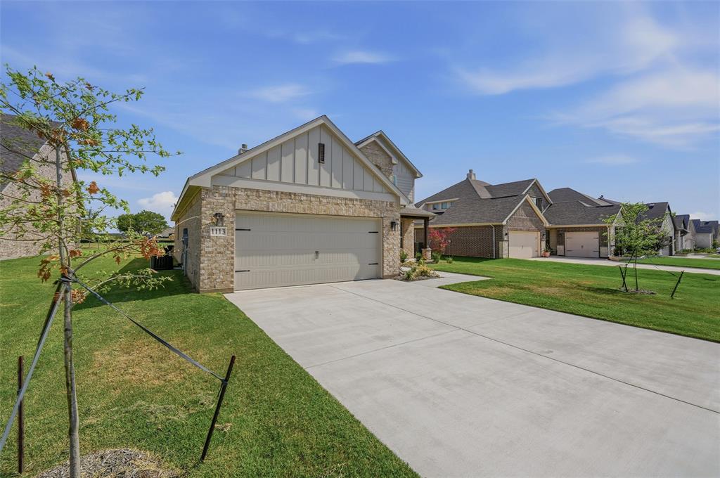 1113 Trinity Drive Springtown, TX 76082 - Photo 3 of 40 Brick exterior with board and batten siding, attached garage, and concrete driveway