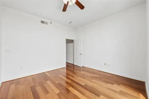 an empty room with ceiling fan and window