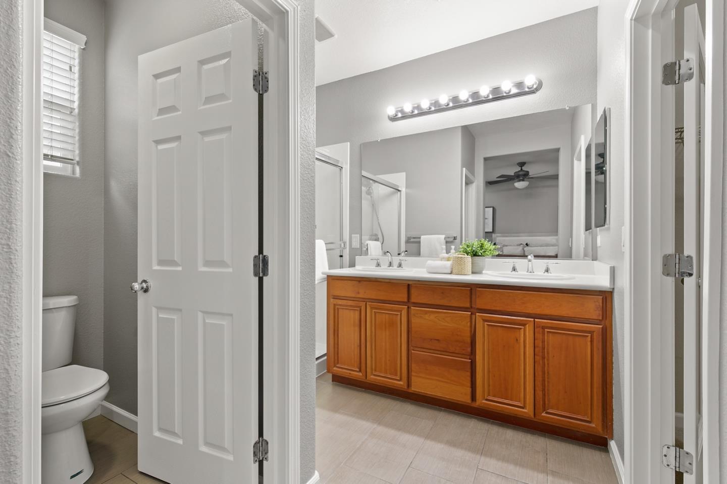 66 Parc Pl Drive Milpitas, CA 95035 - Photo 22 of 34 a bathroom with a granite countertop sink a toilet and a mirror