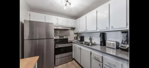 a kitchen with stainless steel appliances granite countertop a refrigerator sink and cabinets