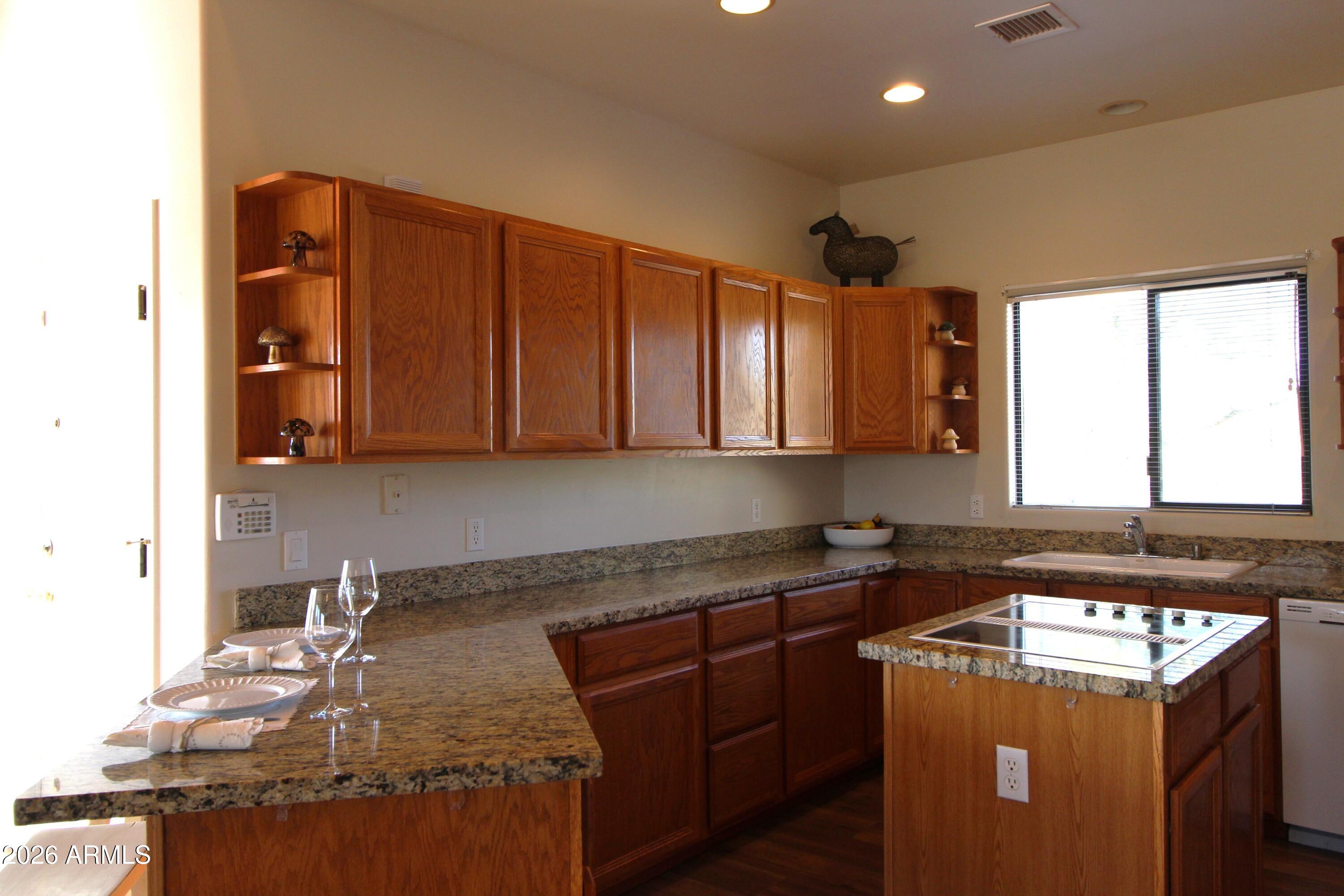1405 East Circle Mountain Road New River, AZ 85087 - Photo 14 of 40 a kitchen with stainless steel appliances granite countertop a sink stove and cabinets