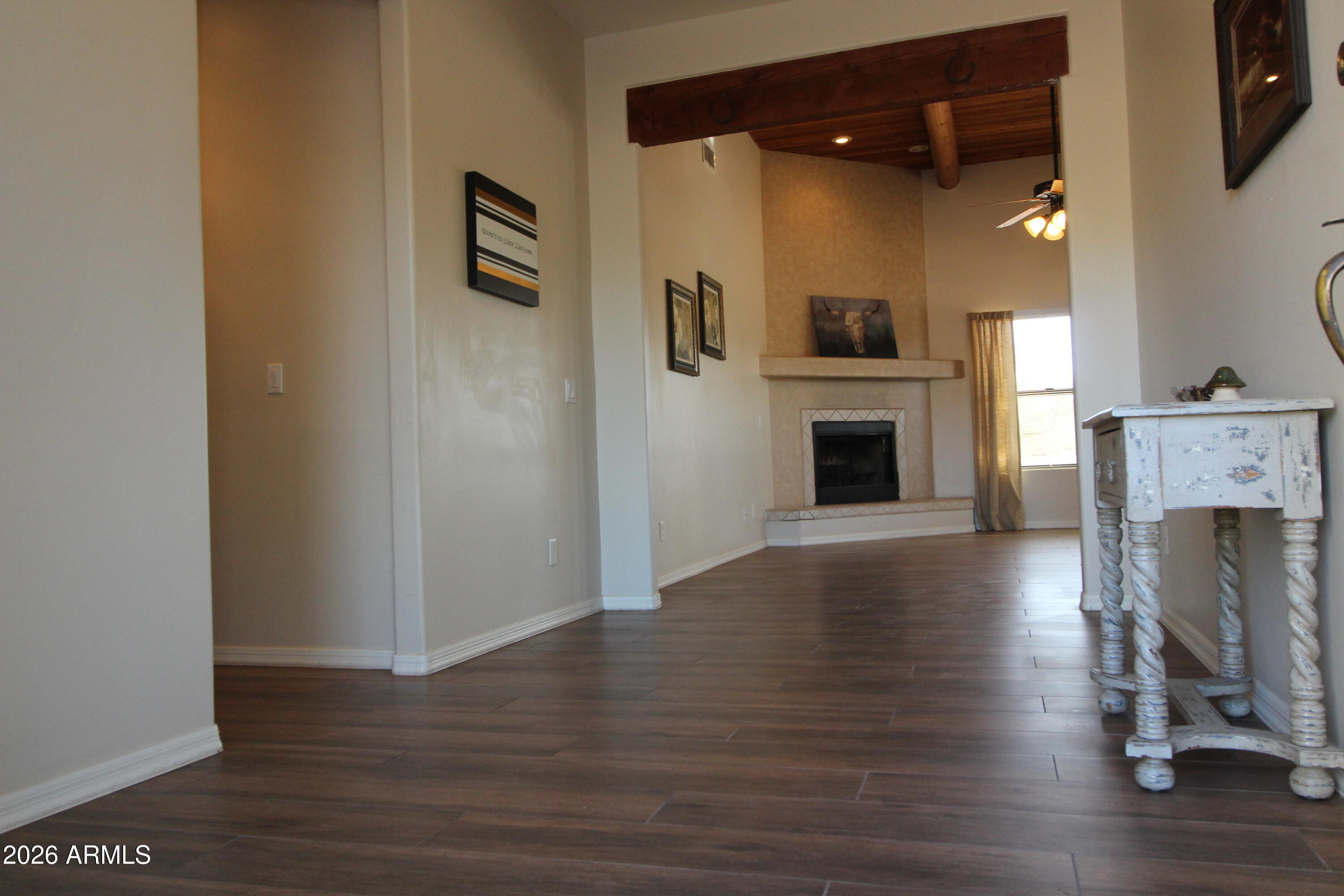 1405 East Circle Mountain Road New River, AZ 85087 - Photo 4 of 40 a view of a livingroom with a fireplace a ceiling fan and wooden floor