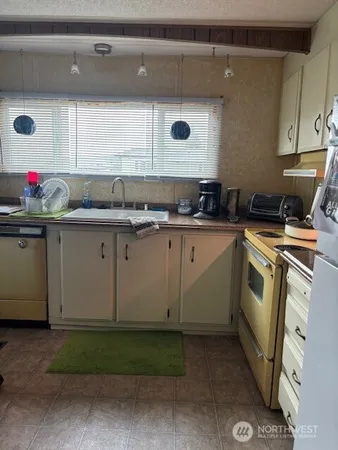 a kitchen with a sink a stove and cabinets