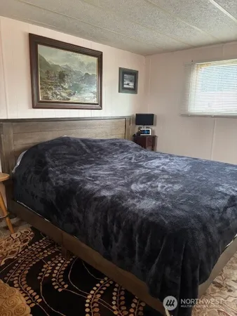 a bedroom with a bed dresser and a window