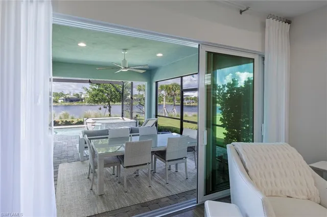 a dining room with furniture and a floor to ceiling window